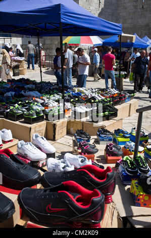 Un vendeur de chaussures affiche sa marchandise à l'extérieur de la Porte de Damas dans l'espoir pour les entreprises à partir de vendredi les fidèles à leur sortie de la vieille ville. Jérusalem, Israël. 21-Septembre-2012. Des milliers de fidèles d'Al-Aqsa se disperser tranquillement après la prière du vendredi à la Porte de Damas. Un petit groupe d'une centaine d'une étape symbolique, dix minutes, de protestation contre "l'innocence des musulmans' film insultant Mahomet et partisans. Banque D'Images