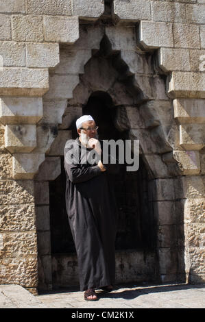 Un religieux musulman se tient sur le côté et regarde protestataires à la Porte de Damas. Jérusalem, Israël. 21-Septembre-2012. Des milliers de fidèles d'Al-Aqsa se disperser tranquillement après la prière du vendredi à la Porte de Damas. Un petit groupe d'une centaine d'une étape symbolique, dix minutes, de protestation contre "l'innocence des musulmans' film insultant Mahomet et partisans. Banque D'Images