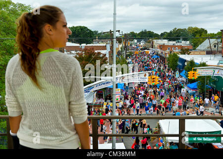 22 septembre 2012 - Bellmore, New York aux États-Unis - Vue de dessus de la 26e assemblée annuelle de la famille Bellmore Festival de rue, à partir de la plate-forme de train surélevé Bellmore Long Island Railroad (LIRR) station, with young woman standing on platform et face à l'Est, la direction vient de train sur cette piste. Plus de gens que le bien plus de 120 000 qui ont assisté à la Long Island juste l'année dernière étaient attendus. Banque D'Images