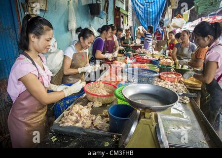 26 septembre 2012 - Bangkok, Thaïlande - paquet femmes morceaux de poulet sur un stand dans un marché de Khlong Toey à Bangkok. Khlong Toey (également appelé Khlong Toei) Marché est l'un des plus importants marchés ''wet'' en Thaïlande. Le marché est situé au milieu d'un des plus grands bidonvilles de Bangkok et à proximité de la ville d'origine du port en eau profonde. Des milliers de personnes vivent dans le bidonville voisin. Des milliers d'autres shop dans le vaste marché pour les fruits et légumes frais et la viande, le poisson et la volaille. (Crédit Image : © Jack Kurtz/ZUMAPRESS.com) Banque D'Images