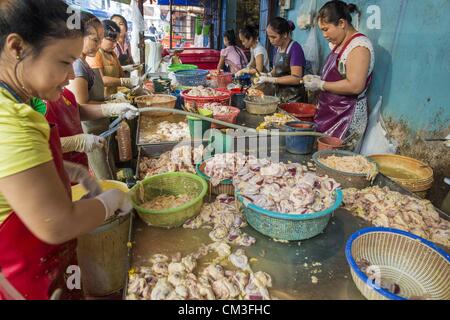 26 septembre 2012 - Bangkok, Thaïlande - paquet femmes morceaux de poulet sur un stand dans un marché de Khlong Toey à Bangkok. Khlong Toey (également appelé Khlong Toei) Marché est l'un des plus importants marchés ''wet'' en Thaïlande. Le marché est situé au milieu d'un des plus grands bidonvilles de Bangkok et à proximité de la ville d'origine du port en eau profonde. Des milliers de personnes vivent dans le bidonville voisin. Des milliers d'autres shop dans le vaste marché pour les fruits et légumes frais et la viande, le poisson et la volaille. (Crédit Image : © Jack Kurtz/ZUMAPRESS.com) Banque D'Images