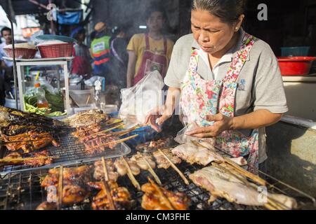 26 septembre 2012 - Bangkok, Thaïlande - Un vendeur de rue, des barbecues poulet sur Khlong Toey Market à Bangkok. Khlong Toey (également appelé Khlong Toei) Marché est l'un des plus importants marchés ''wet'' en Thaïlande. Le marché est situé au milieu d'un des plus grands bidonvilles de Bangkok et à proximité de la ville d'origine du port en eau profonde. Des milliers de personnes vivent dans le bidonville voisin. Des milliers d'autres shop dans le vaste marché pour les fruits et légumes frais et la viande, le poisson et la volaille. (Crédit Image : © Jack Kurtz/ZUMAPRESS.com) Banque D'Images