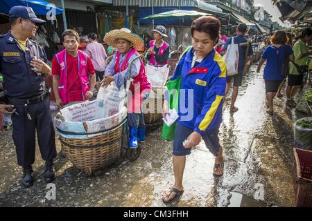 26 septembre 2012 - Bangkok, Thaïlande - un des officiers de police et les porteurs dans un coin à Khlong Toey Market à Bangkok. Khlong Toey (également appelé Khlong Toei) Marché est l'un des plus importants marchés ''wet'' en Thaïlande. Le marché est situé au milieu d'un des plus grands bidonvilles de Bangkok et à proximité de la ville d'origine du port en eau profonde. Des milliers de personnes vivent dans le bidonville voisin. Des milliers d'autres shop dans le vaste marché pour les fruits et légumes frais et la viande, le poisson et la volaille. (Crédit Image : © Jack Kurtz/ZUMAPRESS.com) Banque D'Images