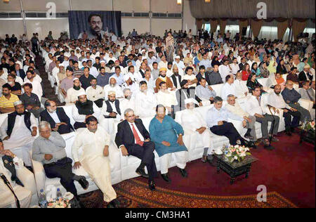 Les partisans de l'Muttehda Qaumi Movement (MQM) écouter le discours du chef téléphonique MQM Altaf Hussain pendant un séminaire sur 'Ishq-e-Rasool (SAW) aur Humara Rawaiyya" (l'amour avec le prophète (SAW) et notre attitude) tenue à l'hôtel local à Karachi, le mercredi 26 septembre, 2012. Banque D'Images