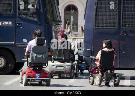 Athènes, Grèce, le 27 septembre 2012. Les personnes handicapées se rassemblent devant le Parlement pour protester contre les réductions des prestations et de la détérioration du système de soins de santé. Sur la photo, les personnes handicapées en fauteuil roulant d'essayer de passer par la police anti-émeute d'autobus. Credit : Nikolas Georgiou / Alamy Live News Banque D'Images