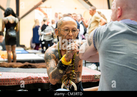 28 septembre 2012, Londres, Royaume-Uni. La 8ème Convention de Tatouage de Londres commence aujourd'hui au quai du tabac dans l'East End de Londres. Tattoo tatoueurs et fans du monde entier affluent vers le lieu. Le tatouage traditionnel à la main-taraudeuses d'Indonésie. Banque D'Images