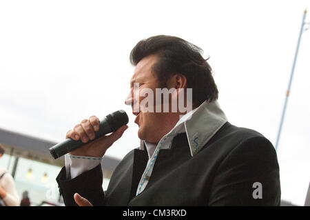 28 septembre 2012. Porthcawl, UK. Rockin Dave 42 Cardiff au Pays de Galles, de sensations fortes d'un public à l'extérieur d'un café promenade. Des milliers de fans d'Elvis et assimilés habillé en glitter jumpsuits, surdimensionnés et lunettes noires et des favoris sport quiffs descendre sur la petite station balnéaire victorienne Galles du Sud pour le début du plus grand festival d'Elvis dans le monde. Pendant trois jours ce week-end, plus de 100 spectacles dans différents endroits va transformer cette ville tranquille dans un vivant hommage au roi du rock n' Roll. Crédit photo : Graham M. Lawrence/Alamy Live News. Banque D'Images