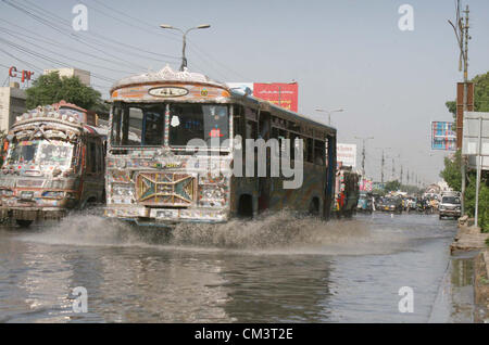 Les banlieusards passent par la stagnation de l'eau d'assainissement s'élèvent à M.A Jinnah Road créant problème dans l'écoulement normal du trafic montrant une négligence de service concerné, à Karachi le vendredi 28 septembre, 2012. Banque D'Images