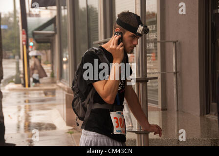 29 septembre 2012 San Antonio, Texas, USA - Au cours de l'CitySolve course urbaine à San Antonio, un homme tente de résoudre des indices à l'aide de son téléphone intelligent. Malgré les fortes pluies, plus de 20 équipes de 2 - 4 personnes ont participé à la course. Banque D'Images