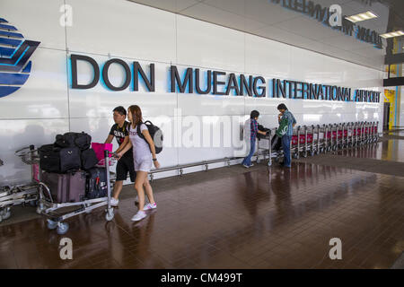 1 octobre 2012 - Bangkok, Thaïlande - Les passagers peuvent y chariots à bagages avant de se rendre à pied à l'Aéroport International de Don Mueang de Bangkok au cours de l'aéroport par la réouverture. L'Aéroport International de Don Mueang est le plus petit de deux aéroports internationaux desservant Bangkok, Thaïlande. Don Mueang a été officiellement ouvert en tant que Royal Thai Air Force base le 27 mars 1914 et les vols commerciaux ont commencé en 1924. L'aéroport de Don Mueang fermée en 2006 suite à l'ouverture de l'aéroport Suvarnabhumi de Bangkok, nouvelle, et rouvert comme un terminal domestique pour les compagnies aériennes à bas prix après rénovation le 24 mars 2007. Banque D'Images