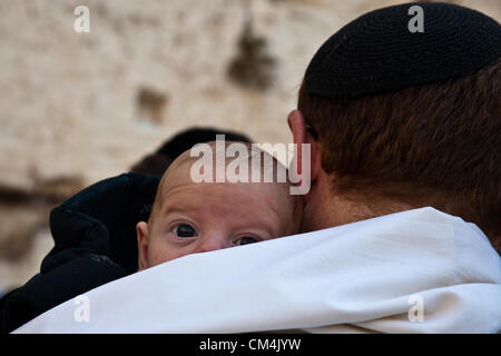 Jérusalem, Israël. 3e octobre 2012. Un homme assiste à un service spécial bénédiction sacerdotale au Mur occidental sur Soukkoth avec son bébé. Jérusalem, Israël. 3-Octobre-2012. Des milliers de pèlerins juifs monter sur le mur ouest de la maison de vacances de Soukkoth, un des trois pèlerinages annuels, pour la bénédiction des prêtres, Birkat Kohanim (hébreu), se produisant deux fois par an. Credit : Alon Nir / Alamy Live News Banque D'Images