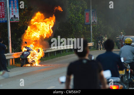 Un scooter à essence brûle hors de contrôle au bord de la route du G301 dans l'est du Hainan. La sécurité des véhicules et des routes a fait l'objet d'un nouvel examen ces dernières semaines après qu'un bus s'est écrasé et brûlé à des occasions distinctes, tuant plus de 40 personnes dans d'autres parties de la Chine. © Olli Geibel Banque D'Images