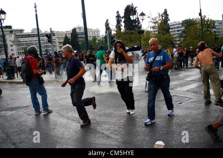 Athènes, Grèce. 9 octobre 2012. Les protestataires s'échapper de l'explosion d'une bombe de gaz lacrymogène. De violents affrontements ont eu lieu au cours d'une protestation anti-Merkel comme Chancelier allemand s'est rendu à Athènes le 9 octobre 2012. Banque D'Images