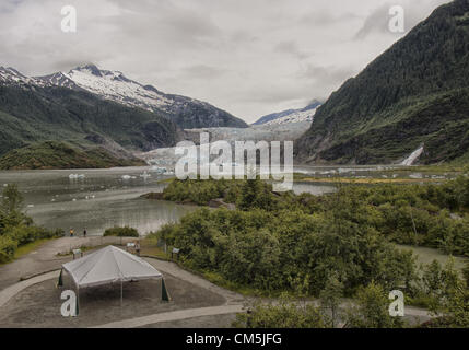 Le 5 juillet 2012 - Arrondissement de Juneau, Alaska, États-Unis - Mendenhall Glacier, entouré par la majestueuse chaîne Côtière, est vue du Glacier de Mendenhall Centre d'accueil. À partir de 1951â€"1958 l'extrémité du glacier, qui se jette dans le lac Mendenhall, de sa source à 12 miles de l'lcefield Juneau, a reculé de 1 900 pieds (580m). Depuis 1958, il a reculé de 1,75 miles (2.82km) lorsque Mendenhall Lake a été créé. Les icebergs flottent à la surface du lac. Plus de 350 000 personnes par an visiter pour voir son visage, un mur de plus de 100 pieds de haut et d'un mille de large. Nugget Falls, également connu sous le nom de ruisseau De Pépite Fa Banque D'Images