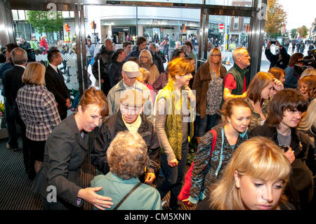 Exeter, Royaume-Uni. 12 octobre 2012. John Lewis Exeter branch manager Kate Connock contribue à un couple de personnes âgées comme clients entrez le nouveau ministère John Lewis store à Exeter, Devon. Credit : Clive Chilvers / Alamy Live News Banque D'Images