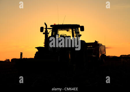 Un tracteur New Holland T7040 et d'une GT300 de pommes de terre Grimme traîné harvester park et mettre fin à leur longue journée en lutte contre l'eau du sol. Les champs humides font qu'il est difficile pour les agriculteurs britanniques pour terminer leur récolte. Crédit : Paul Lilley/Digitalshot.co.uk / Alamy Banque D'Images