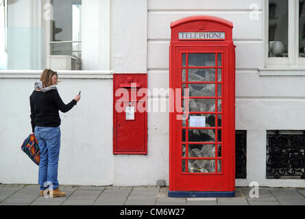 Une cabine téléphonique qui a été rempli avec les mouettes est bruit à Worthing une femme prend une photo sur son téléphone portable Banque D'Images