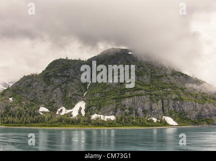 3 juillet 2012 - Glacier Bay, Alaska, États-Unis - une formation de nuages bas au-dessus de l'île plane composite dans l'aqua l'eau coloré de Glacier Bay. Glacier Bay couvre 3,3 millions d'acres (1,3 millions d'hectares) de montagnes escarpées, dynamique des glaciers, forêt tropicale, côtes sauvages, des fjords abrités et la faune. Un point fort de l'Alaska, le passage de l'intérieur et une partie d'un 25 million d'acres (10,1 millions d'hectares) Site du patrimoine mondial, il est le plus grand de la biosphère par l'UNESCO dans le monde. Près d'un demi-million de touristes visitent chaque année, surtout les passagers des navires de croisière. (Crédit Image : © Arnold Drapkin/ZUMAPR Banque D'Images