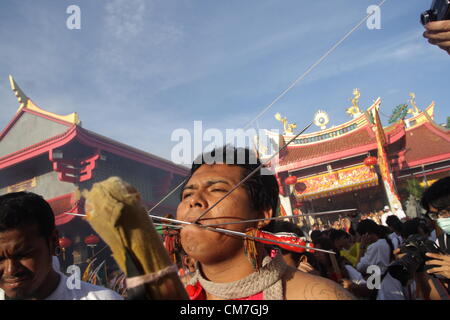 21,10,2012. Phuket , Thailande . Les dévots de l'culte Chinois prennent part à une procession de la rue.Le Festival Végétarien de Phuket commence le premier soir du neuvième mois lunaire et dure neuf jours, les dévots religieux eux-mêmes avec des épées, slash pierce leurs joues avec des objets pointus et commettre d'autres actes douloureux de se purifier Banque D'Images