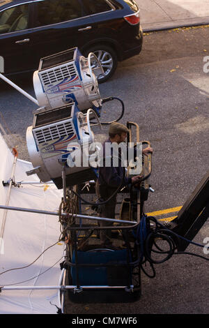 New York USA. Le 22 octobre 2012. Ministère de l'éclairage d'un membre d'équipage de film deux Cinemills déménagement 18/12 Kw Super Silver Bullet projecteurs avec un diffuseur blanc en position sur Wadsworth Avenue dans le quartier d'Inwood de Manhattan à New York City. Banque D'Images