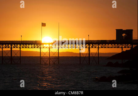 27 octobre 2012 - Mumbles - Swansea - UK : lever de soleil sur l'Mumbles Pier dans le petit village de pêcheurs de Mumbles près de Swansea, dans le sud du Pays de Galles début sur un matin d'automne. Un incendie a éclaté à la jetée dans les premières heures qui, selon la police, pourrait avoir été causé par une étincelle provenant d'un chalumeau pendant le travail de construire une station de sauvetage de 9,5 M €, attisé par le vent. Jean Bollom, le directeur général de Mumbles pier, dit la terrasse en bois a été endommagé, mais la structure principale est très bien. Banque D'Images