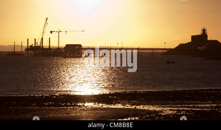 27 octobre 2012 - Mumbles - Swansea - UK : lever de soleil sur l'Mumbles Pier dans le petit village de pêcheurs de Mumbles près de Swansea, dans le sud du Pays de Galles début sur un matin d'automne. Un incendie a éclaté à la jetée dans les premières heures qui, selon la police, pourrait avoir été causé par une étincelle provenant d'un chalumeau pendant le travail de construire une station de sauvetage de 9,5 M €, attisé par le vent. Jean Bollom, le directeur général de Mumbles pier, dit la terrasse en bois a été endommagé, mais la structure principale est très bien. Banque D'Images