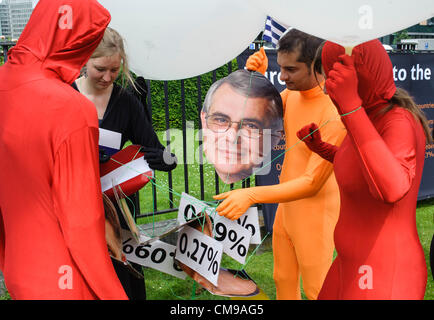 Jeudi 28 juin 2012 - Bruxelles, Belgique. Les manifestants portant des masques des dirigeants de l'Union européenne manifestent devant le Conseil de l'Union européenne siège quelques heures avant le sommet de l'Union européenne. L'Observatoire realeased un rapport qui confirme que l'UE est de loin le plus grand donateur au monde avec 53 milliards d'euros de l'aide au développement en 2011. Le rapport conclut également que les États membres ont besoin d'augmenter leurs budgets d'aide afin de répondre à la promesse de niveau de 0,7 % du RNB consacré à l'aide en 2015. Banque D'Images