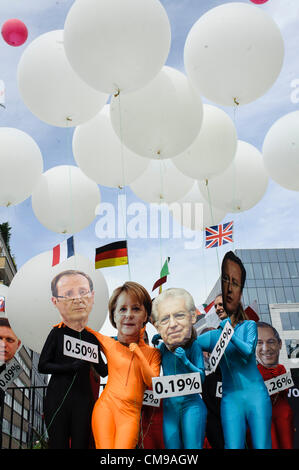 Jeudi 28 juin 2012 - Bruxelles, Belgique. Les manifestants portant des masques des dirigeants de l'Union européenne manifestent devant le Conseil de l'Union européenne siège quelques heures avant le sommet de l'Union européenne. L'Observatoire realeased un rapport qui confirme que l'UE est de loin le plus grand donateur au monde avec 53 milliards d'euros de l'aide au développement en 2011. Le rapport conclut également que les États membres ont besoin d'augmenter leurs budgets d'aide afin de répondre à la promesse de niveau de 0,7 % du RNB consacré à l'aide en 2015. Banque D'Images
