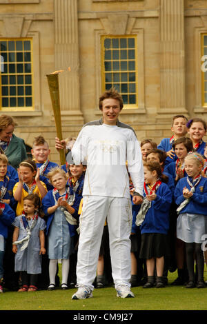 Le Derbyshire, Royaume-Uni. Le vendredi 29 juin 2012. Porteur de Flambeau olympique avec des enfants des écoles locales sur la pelouse Sud, Chatsworth House stately home Chatsworth House est le siège du duc de Devonshire et a été le foyer de la famille Cavendish depuis 1549. Banque D'Images