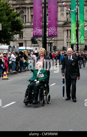 30 juin 2012. Journée des Forces armées, George Square, Glasgow, Ecosse, Royaume-Uni. Ian Stewart, âgé de 87, Maître de marine retraité, dans le fauteuil, et Robert Grant, âgée de 93 ans, ancien matelot non handicapés marchant à côté, au défilé de la Journée des Forces armées dans la région de George Square, Glasgow, Écosse, Royaume-Uni, Grande Bretagne. Ian Stewart est poussé par l'infirmière Alison Connelly. Les deux hommes ont été les plus anciens militaires participant à la parade. Banque D'Images