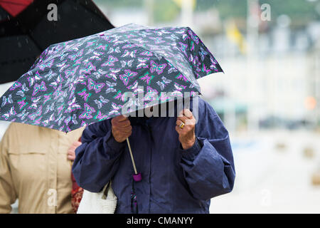 Aberystwyth, Pays de Galles, Royaume-Uni. Vendredi 6 juillet 2012 personnes à Aberystwyth à l'abri de la pluie. L'Agence de l'environnement a émis des alertes Amber avertissement du risque d'inondation sur les rivières au Pays de Galles, et l'équivalent d'un mois de pluie est prévu à l'automne dans les régions du Royaume-Uni en seulement un jour. photo ©keith morris Banque D'Images