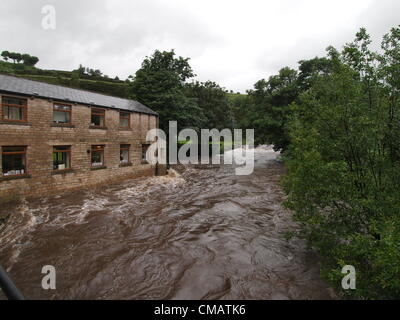 Apprivoiser la rivière en crue menace house dans la zone rapide inférieur de Tameside, Oldham, UK, le vendredi 6 juillet 2012 Banque D'Images