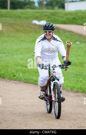 6 juillet 2012. Hadleigh Farm, Hadleigh, Essex, Royaume-Uni. Le relais de la Flamme Olympique a visité les cours de vélo de montagne à Hadleigh Farm dans le sud de l'Essex. Dan Jarvis porté le flambeau sur une petite boucle de la course avant de céder la place à l'autre coureur, Kim Axford. Banque D'Images