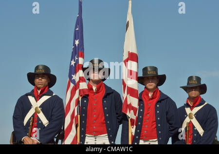 Niantic, Connecticut, le 6 juillet 2012 - La garde d'honneur de gauche à droite : Garde côtière américaine Seaman Azaert Annex Rivera, le Marin Jon Waldrop, Seaman Seaman Ryan Elliott Gray et Gordon habillés en uniforme d'époque 1812 comme ils l'auraient porté au Service de coupe, le prédécesseur de l'actuelle à la Garde côtière des États-Unis, présente les couleurs pour l'OpSail Comité. La cérémonie a eu lieu le jour de l'ouverture de Voile Opération New York, commémorant le bicentenaire de la guerre de 1812 et l'écriture de la Star Spangled Banner, l'hymne national américain. Les marins sont en poste à Washington, D.C. Banque D'Images