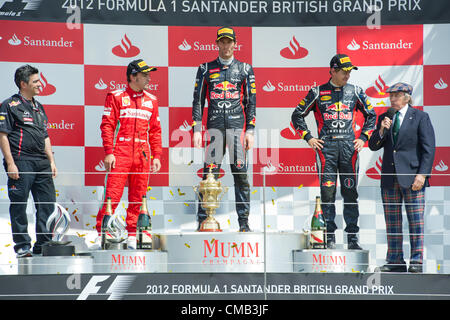 08.07.2012 Towcester, Angleterre. Pilote de Formule 1 espagnol Fernando Alonso (2L-R, 2e) de Ferrari, Australian Mark Webber (1er) de Red Bull, son coéquipier l'allemand Sebastian Vettel (3e) et ancien pilote de F1 British Sir Jackie Stewart sur le podium après le Grand Prix de Grande-Bretagne sur le circuit de Silverstone dans le Northamptonshire, Angleterre, 08 juillet 2012. Banque D'Images