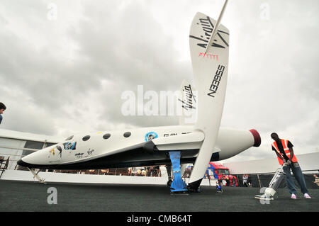 Virgin's maquette de Galactic's Space Ship ( SS2) exposée tandis qu'un nettoyant prépare les dernières minutes au stand Virgin au Farnborough International Airshow 2012, Angleterre, Royaume-Uni Banque D'Images