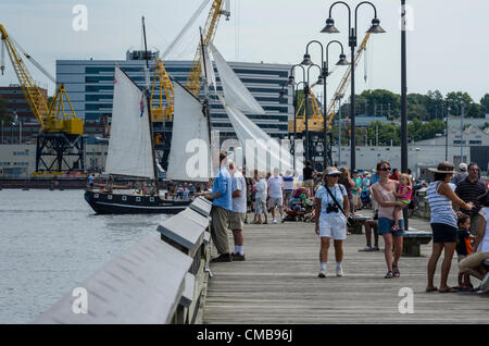 New London, Connecticut, USA - 9 juillet 2012 : les foules se rassemblent pour voir les grands voiliers naviguer loin de Fort Trumbull à leurs ports d'attache comme OpSail 2012, pour célébrer le bicentenaire de la guerre de 1812 et l'écriture de la Star Spangled Banner, l'hymne national américain, tire à sa fin. Le loup, un 74 pied topsail schooner de Key West, en Floride, par voiles. Banque D'Images