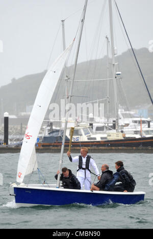 La flamme olympique a fait son chemin par la mer, mais seulement après un changement de dernière minute du plan. Avec des vents et de la pluie c'était dangereux d'autoriser deux jeunes à faire la traversée à Weymouth sorte Rodney Pattisson Stuart MBE, un ancien gagnant de la médaille d'or en double a pris la flamme dans un yacht de la Sailing Academy à Portland. Il a remporté le double de médailles d'or aux Jeux olympiques de voile à l'Jeux olympiques de Mexico 1968 et 1972 Jeux Olympiques de Munich. 12/07/2012 Photo par : DORSET MEDIA SERVICE Banque D'Images