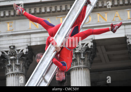 Londres, Royaume-Uni. 15 juillet 2012. Les artistes interprètes ou exécutants s'accrocher à l'échelle de filature. Une journée extraordinaire, surprises : Streb. Chorégraphe Elizabeth Streb et sa compagnie de danse New York 'Action Heroes' avec leurs performances dans l'ASCENSION avant de la Galerie nationale. Banque D'Images