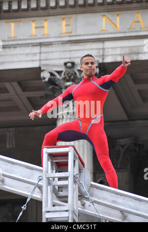 Londres, Royaume-Uni. 15 juillet 2012. Un artiste interprète ou exécutant points à la foule. Une journée extraordinaire, surprises : Streb. Chorégraphe Elizabeth Streb et sa compagnie de danse New York 'Action Heroes' avec leurs performances dans l'ASCENSION avant de la Galerie nationale. Banque D'Images