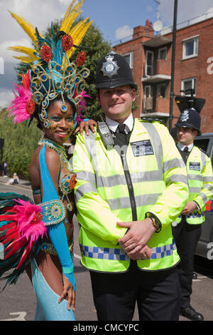 Hackney, Londres, Royaume-Uni. Samedi, 21 juillet 2012. Défilé du carnaval de rue Pitfield à Stoke Newington à celui d'Hackney Festival 2012. Le festival est une journée de corvées de activité, qui aura lieu le samedi, 21 juillet 2012 Bienvenue à la torche olympique sur la première journée à Londres. Danseur de la London School of Samba posant avec un policier. Banque D'Images