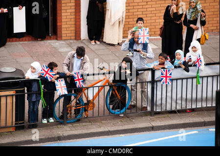 Londres, Royaume-Uni - 21 juillet 2012 : une famille musulmane attend que le flambeau olympique à Whitechapel Road juste en face de l'East London Mosque le deuxième jour du Ramadan. Banque D'Images