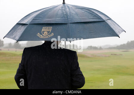 23 juillet 2012, Kilmarnock (Barassie) Golf Club, Troon, l'Ayrshire. Alex Stevens, starter officiel protège sous un parapluie à l'entrée donnant sur la première voie d'accès à la R et D'UN Seniors Open compétition de qualification pour les Seniors Open qui se tiendra plus tard à Turnberry. Banque D'Images