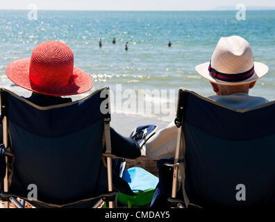 Lundi 23 juillet 2012, West Wittering beach, West Sussex, Angleterre, Royaume-Uni. Un couple de retraités profiter du soleil à West Wittering Beach sur la côte du Sussex de l'Ouest. Après un été humide très beau temps revient à certaines parties du Royaume-Uni au cours de la fin de semaine. Les stations balnéaires de la côte sud a vu un grand nombre d'holdaymakers profitez de la pause dans le temps. Banque D'Images