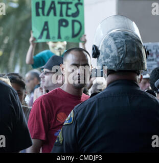 24 juillet 2012 - Anaheim, Californie, USA. Un manifestant s'éteint en face d'une ligne d'attaque composée de Police Anaheim devant l'hôtel de ville mardi après-midi. Une foule de plusieurs centaines de personnes se sont réunis devant l'Hôtel de Ville d'Anaheim mardi après-midi pour protester contre la mort de Manuel Diaz par Anaheim Police le samedi. Banque D'Images