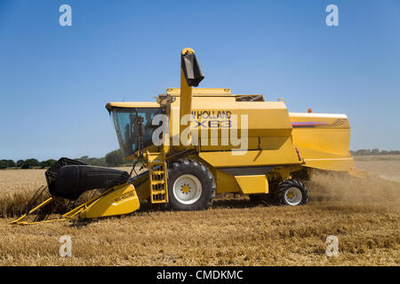 New Holland TX63 combine harvester peignant l'orge dans le Norfolk, Royaume-Uni contre un ciel d'été bleu Banque D'Images