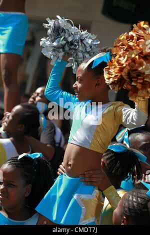 Londres, Royaume-Uni. La torche olympique est transmises par l'entremise de Notting Hill Gate à Kensington et Chelsea dans l'après-midi du 26 juillet 2012 Prix de la Couronne par Frederik de Danemark. La foule et les danseurs de profiter de la journée. Banque D'Images