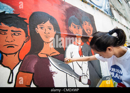 Un élève applique détails pour une peinture murale représentant la révolution philippine dans le cadre d'un concours d'art à l'Université des Philippines à Manille, Philippines, 27 juillet, 2012. La Révolution philippine s'est produite en 1896 qui a abouti à la sécession de l'îles des Philippines de l'Empire espagnol. Banque D'Images