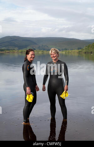 Nageurs de charité portant des combinaisons humides dans le plus grand lac naturel du Semer Water Yorkshire près du magnifique village de Hawes dans le North Yorkshire.Julie Woodhead et Gill Greaves se sont produits lors de la immersion Sue Ryder dans les Dales du North Yorkshire, une nage caritative annuelle d'un kilomètre qui a lieu le samedi 4 août 2012 Banque D'Images