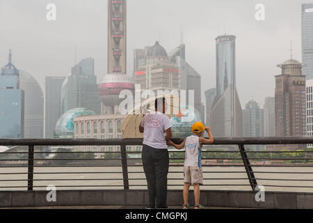 Les visiteurs de la Bund se mettre à l'abri de vents en rafales comme Typhon Haikui a atteint les côtes de l'est de la Chine d'effectuer vie de 23 millions de personnes dans le centre des affaires de Shanghai le 8 août 2012 à Shanghai, Chine. Banque D'Images